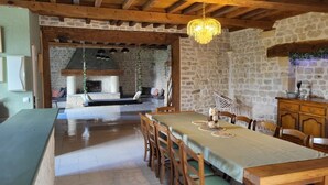 A rustic dining area with a long wooden table, chairs, and a hanging chandelier. - House in the countryside near Omaha Beach! Pets allowed (Mandeville-en-Bessin)
