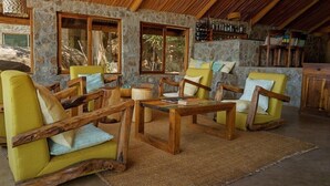 A rustic interior with stone walls, wooden furniture, and a bar area. - Lukuba Island Lodge (Musoma)