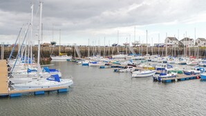 A marina with numerous boats docked, a wooden pier, and houses in the background. - 1 bedroom accommodation in Tayport, near St Andrews (Tayport, near St Andrews)