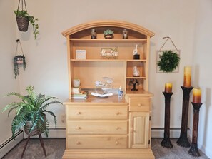 Un bureau en bois doté d’une étagère, de tiroirs et d’un panier suspendu contenant une plante.