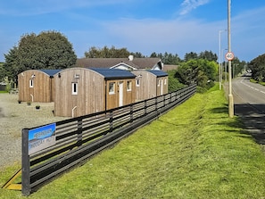 Eine Holzhütte für Urlaubszwecke, mit einem Schild, das anzeigt, dass dies ein Standort von 'Holiday Huts' ist.