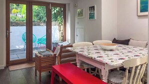 Un comedor con una mesa, sillas y una banca.