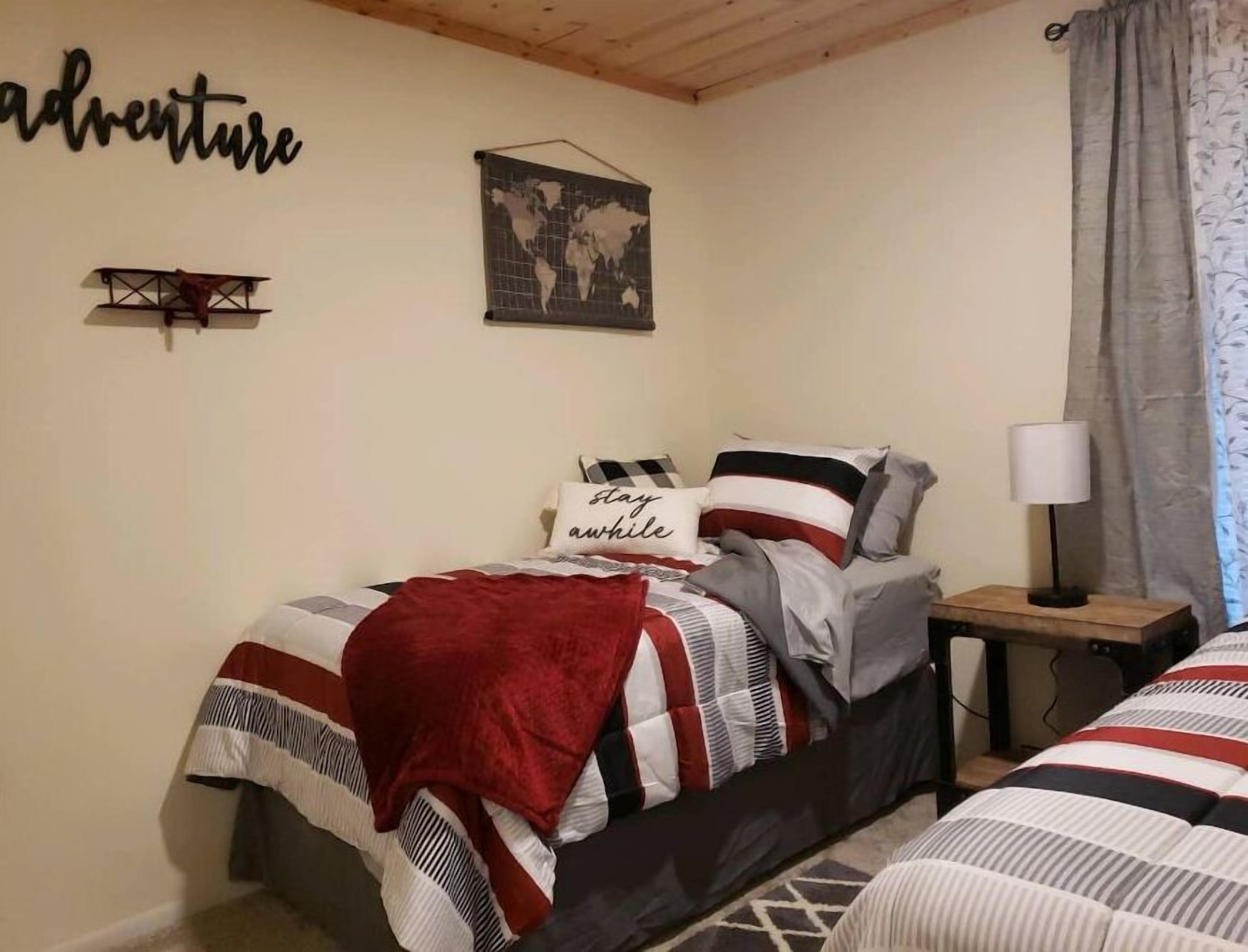 A bedroom with a bed, a world map, and a sign saying "adventure".
