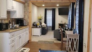 A compact living space with a kitchen, dining area, and a seating area. - Park View Place 4 Blocks From the World's Biggest (Casey)