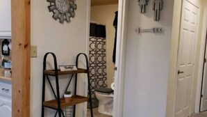 A hallway with a wooden ceiling, a metal shelf, and a wall-mounted clock. - Park View Place 4 Blocks From the World's Biggest (Casey)
