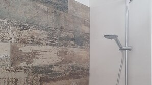 Eine Dusche mit Handbrause und Deckenbrause.