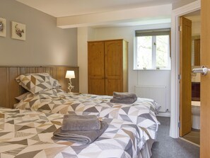 Une chambre à coucher avec un lit, une armoire en bois et une fenêtre.