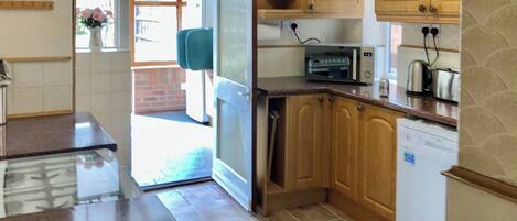 Oppvaskmaskin, høy barnestol og kjøkkenutstyr