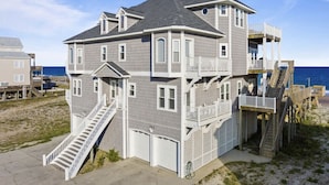 A multi-story beach house with a staircase leading to the main entrance, a balcony, and a deck area. - 6 BR/5.5 baths on quiet beach.  Penthouse suite.  Free linens.  Gorgeous views! (North Topsail Beach)