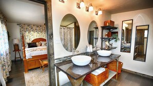 Un bagno con due lavandini, un grande specchio e un mobile contenitore in legno.
