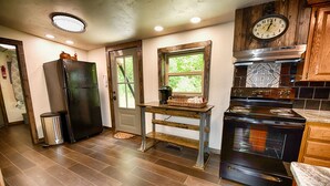 Una cucina con frigorifero, fornello e mobili in legno.