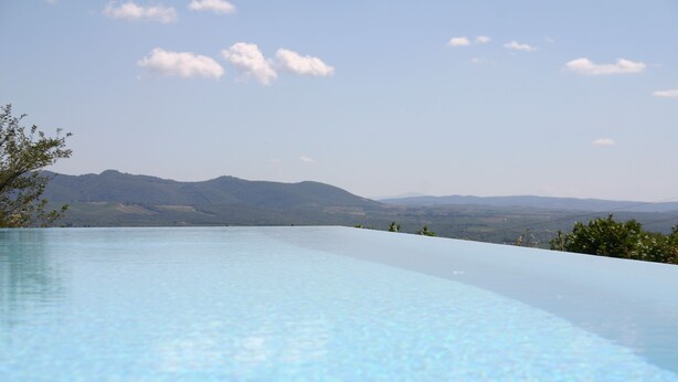 A clear view of an infinity pool with a mountain backdrop. - Traumblick in die Toskana - Appartment mit Pool auf Hügel zw. Siena u. Florenz (Toscana)