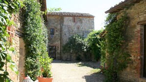 A narrow alleyway with a gravel path, flanked by stone buildings with ivy-covered walls. - Traumblick in die Toskana - Appartment mit Pool auf Hügel zw. Siena u. Florenz (Toscana)