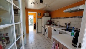 Una cucina accessoriata con lavatrice, forno a microonde e lavello. Una finestra offre vista sull'esterno.