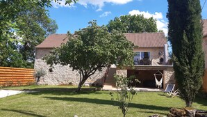 A stone house with a tiled roof, a small lawn, and a tree in the foreground. - Bergerie du Mas de Darre (with spa, terrace and garden) between Lot and Aveyron. (Sainte-Croix)