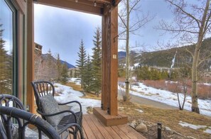 A wooden deck with a view of a snowy landscape and trees. - Tenderfoot Lodge 2604 (Keystone)