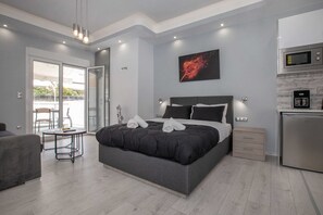 Un dormitorio moderno con una cama grande, una mesa de comedor y un kitchenette.