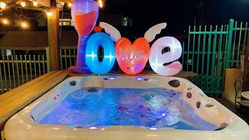 Relax in the hot tub surrounded by a wooden deck, complete with a heater.