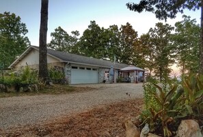 A house with a gravel driveway, a garage, and a covered porch area.