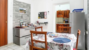 Una cocina compacta con comedor, refrigerador y microondas.