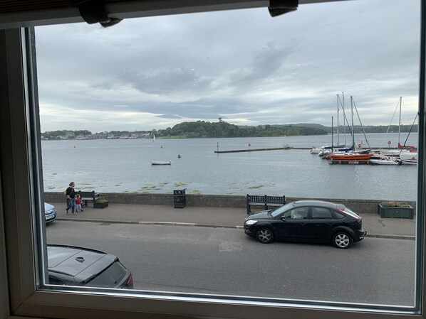 A view of a harbor with boats, a car, and a person walking on the sidewalk. - Luxury Town House with Sea View and Hot Tub (Portaferry)