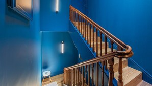 A staircase with wooden balusters and a blue wall.