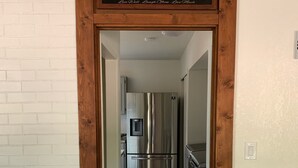 A hallway leading to a kitchen with a stainless steel refrigerator and a water dispenser. - Peaceful Sedona retreat with red rock views, walk to Sedona Golf Resort (Sedona)