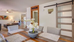 A dining area with a wooden table, white chairs, and a centerpiece of white flowers in a bowl. - Peaceful Sedona retreat with red rock views, walk to Sedona Golf Resort (Sedona)