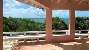 A covered patio with a view of the ocean, surrounded by lush greenery. - Private Waterfront  Home With 180* Sea Views - 2 Bed / 2Bath (Spanish Wells)