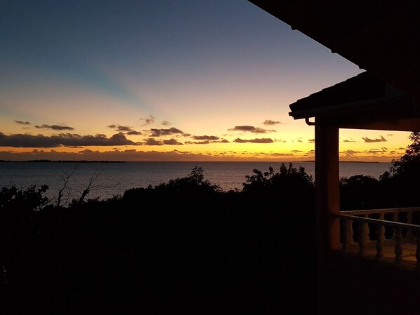 A sunset view from a covered balcony overlooking a body of water. - Private Waterfront Home With 180* Sea Views - 2 Bed / 2Bath (Spanish Wells)