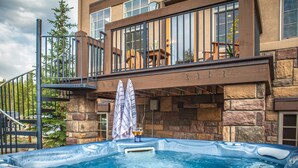 A hot tub in front of a stone building with a balcony. - Luxury Downtown Condo - Private Hot Tub! Walk to Dining and Ski Bus... (Winter Park)