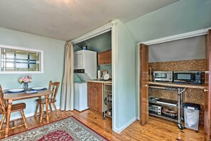 A compact kitchen with a microwave, toaster, and a small cabinet.