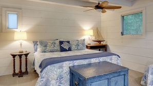 A bedroom with a bed, two bedside tables, a ceiling fan, and a window. - 'Nantucket Cottage' w/ Fishing Dock + Sunsets (Fernandina Beach)