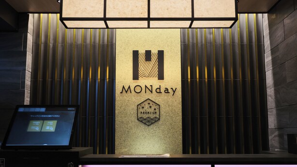 Un comptoir d’accueil orné d’un logo sur lequel on peut lire « MONday » et d’un badge indiquant « PREMIUM ».