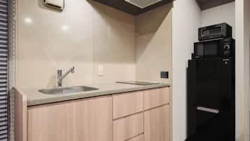 A modern kitchen with a sink, countertop, and built-in microwave.