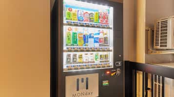 Un distributeur automatique proposant une variété de boissons et portant une indication précisant qu’il est en service le lundi.