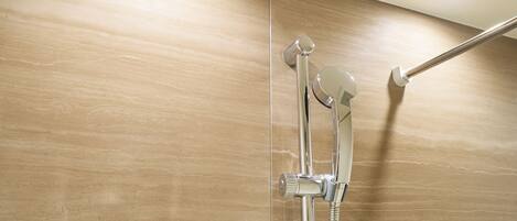 A shower with a chrome handle and hose, mounted on a wall with a wooden panel design.