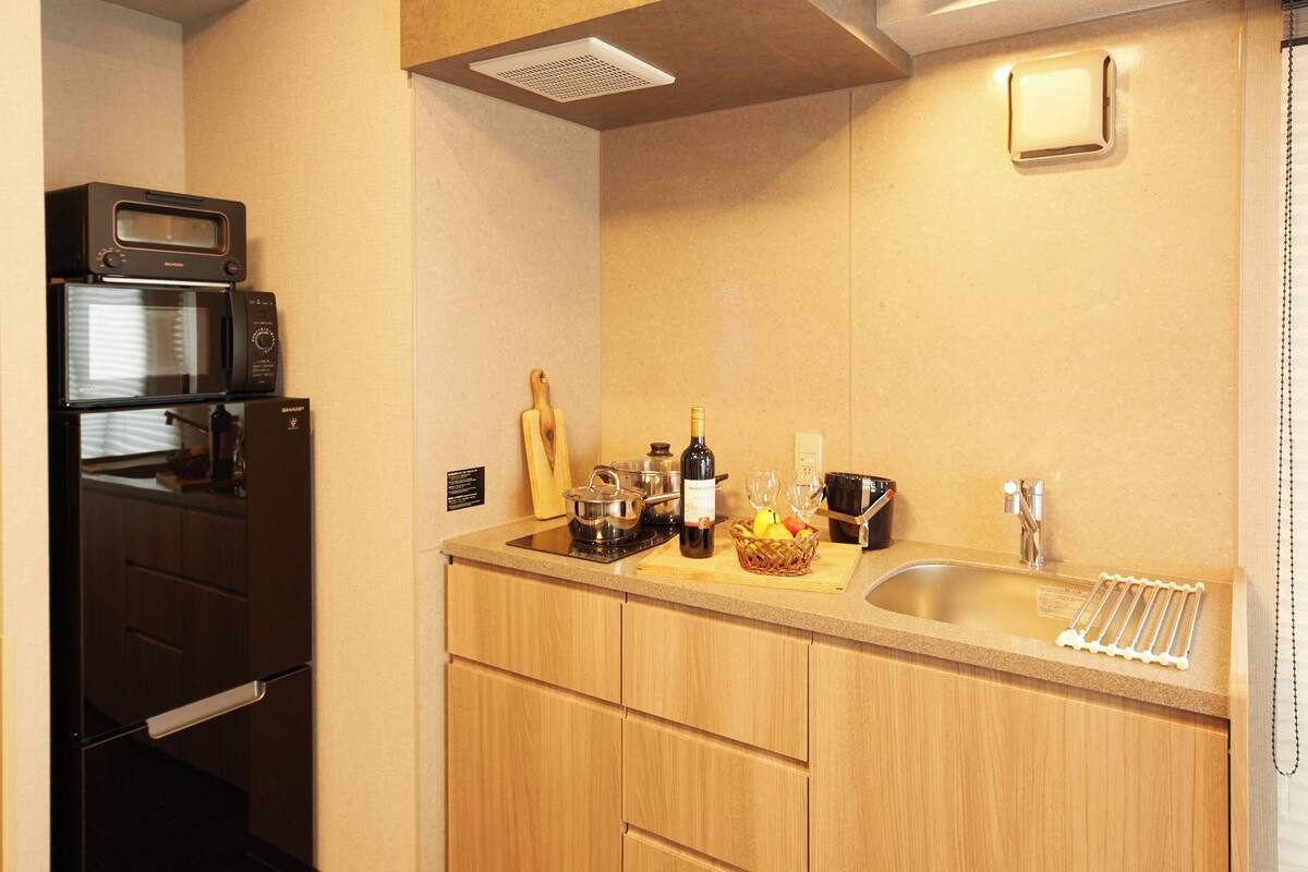 A compact kitchen with a microwave, stove, and sink.