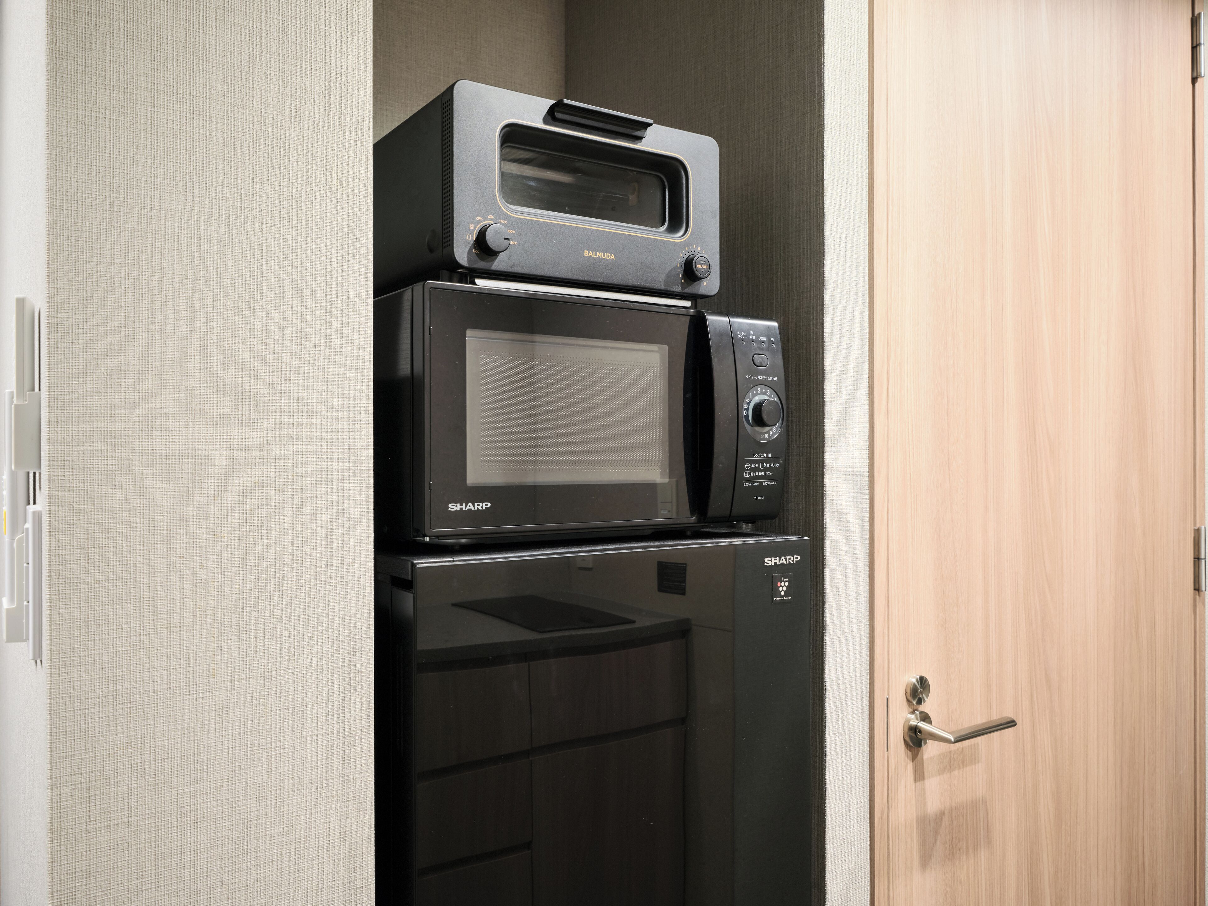 Une cuisine compacte équipée d’un four à micro-ondes et d’un four traditionnel.