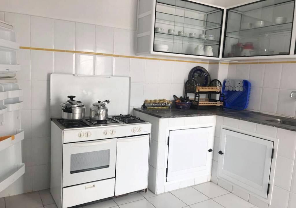 A compact kitchen with white cabinetry, a gas stove, and a built-in oven.