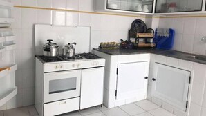 A compact kitchen with white cabinetry, a gas stove, and a built-in oven.
