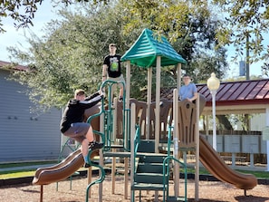Kids can play and climb on the playground structure with multiple slides.