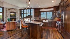 Una cocina amplia con chimenea de piedra, ventanas grandes y una zona de bar.