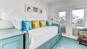 A bedroom with a bed, a nightstand, a dresser, and a window with blinds.