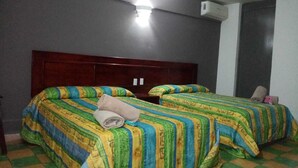 A room with two beds, a wooden headboard, a wall-mounted air conditioner, and a checkered floor. - Hotel Verasol (Veracruz)