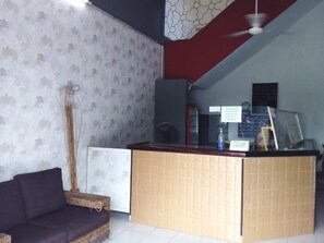 A reception area with a reception desk, a sofa, and a patterned wall. - Hotel Verasol (Veracruz)