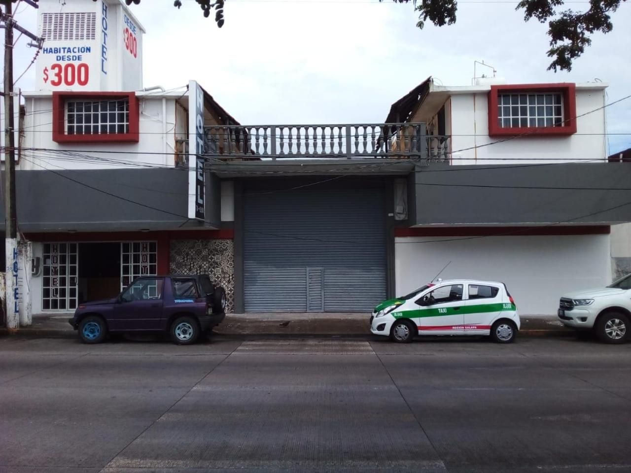 Un edificio con puerta de garaje cerrada, un balcón y un letrero que indica un precio de $300.