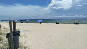 A beach with umbrellas and beach chairs, a trash can, and a wooden post. - Fish, Beach, Pool, Swim, Relax in Luxury Rent for the month only 5,900.00 (Carrabelle)