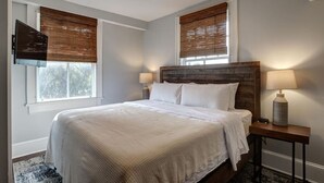 Een slaapkamer met een groot bed, twee bedlampen en een houten hoofdeinde.