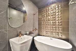 A modern bathroom with two sinks, a large bathtub, and a decorative wall panel. - Best Louis Hamilton Hotel Gijang (Busan)